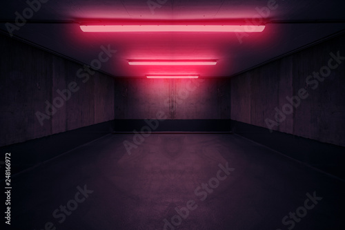 dark underground room with red neon light in basement or parking lot -