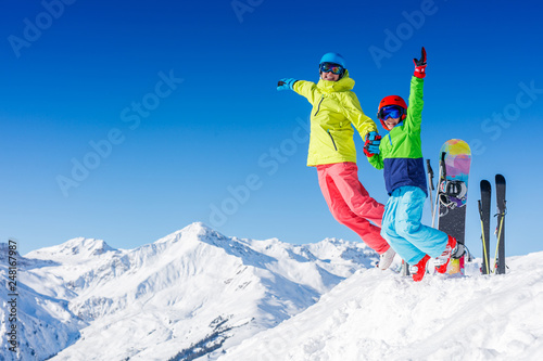Skiing, winter, snow, sun and fun - kids, boy and girl jumping and having fun in the Alps. Child skiing in the mountains.