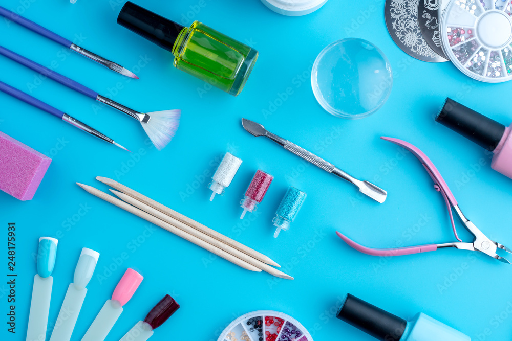 Set of cosmetic tools for professional manicure and nail care on blue background. Top view Set of cosmetic tools for professional manicure and nail care on blue background. Top view