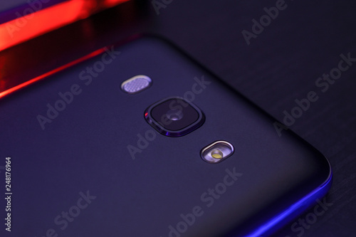 Close-up black phone case with creative blue and red backlight. Macro horizontal photography