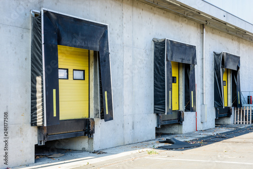 Принти на полотні Three truck loading docks with rubber seals in the concrete wall of a warehouse in the suburbs of Paris, France, with a closed yellow roller shutter door