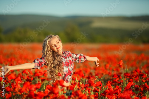 Fototapeta Naklejka Na Ścianę i Meble -  Young blonde in a red shirt in the poppy flower field.