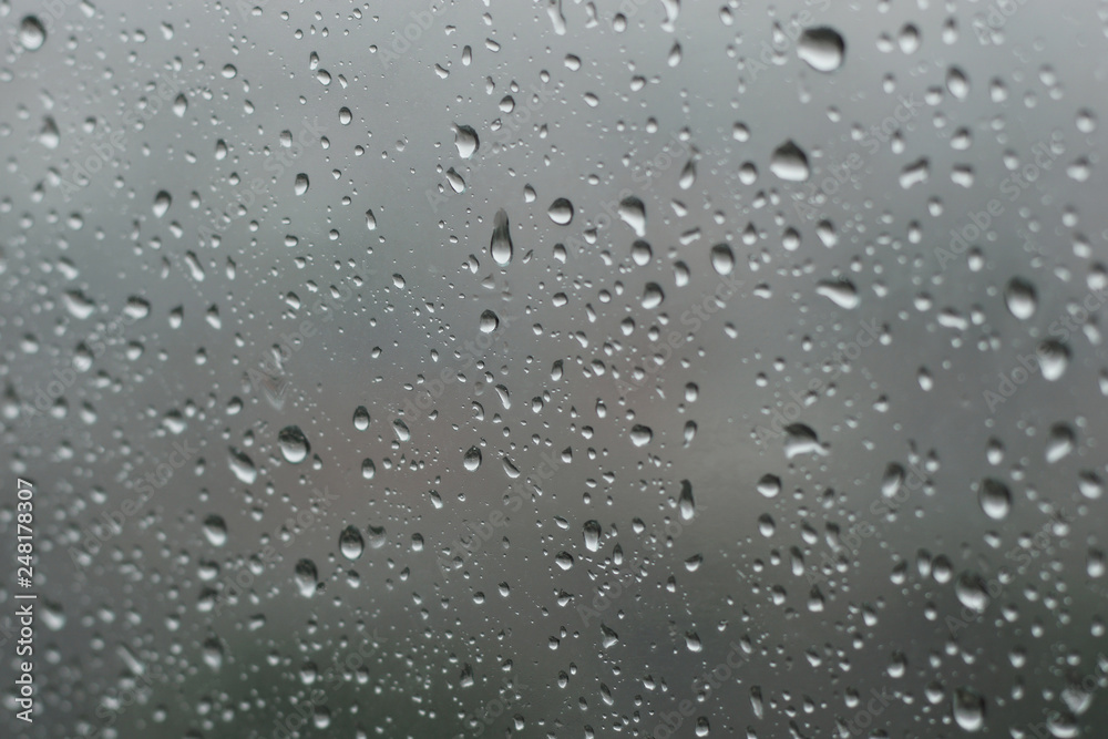 raindrops on glass window in grey background