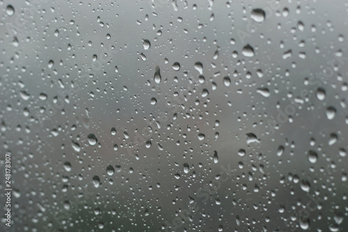raindrops on glass window in grey background