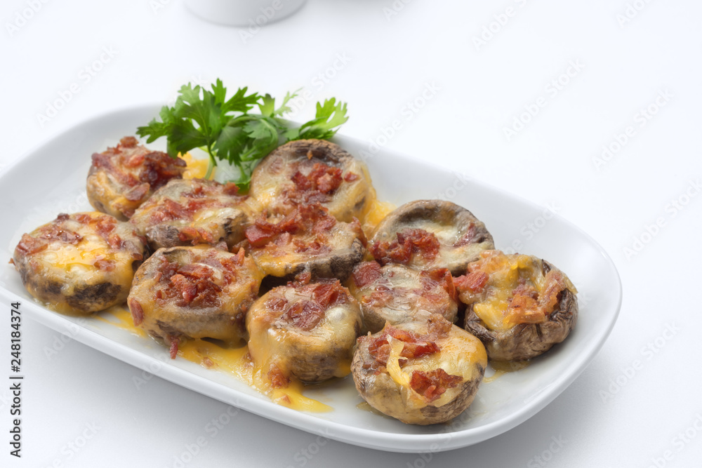 Cheese and bacon stuffed mushroom caps baked in the oven on white background Cheese and bacon stuffed mushroom caps baked in the oven on white background