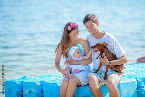 young stylish hipster couple in love walking playing dog in tropical beach, white sand, cool outfit, romantic mood, having fun, sunny, man woman together horizontal, vacation © ElenaBatkova