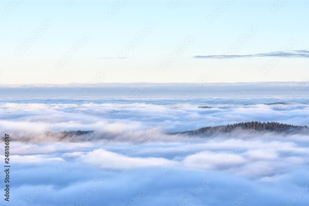 Forested hills sticking out of a sea of clouds. Bavaria, Germany