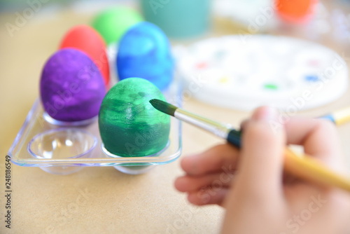 Happy Easter Day. Easter eggs concept. A girl hand painting Easter eggs. Happy family preparing for Easter.