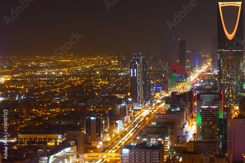 Panorama view to the skyline of Riyadh by night, with the Kingdom centre in the background and yellow lighting, the capital of Saudi Arabia photo