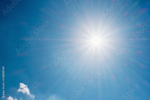 Blue sky with sun and clouds background.