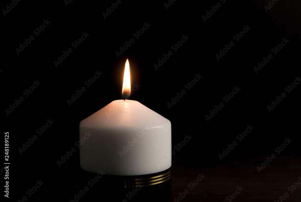 White candle with black ribbon, symbol of remembrance or mourning, black background. Lot of