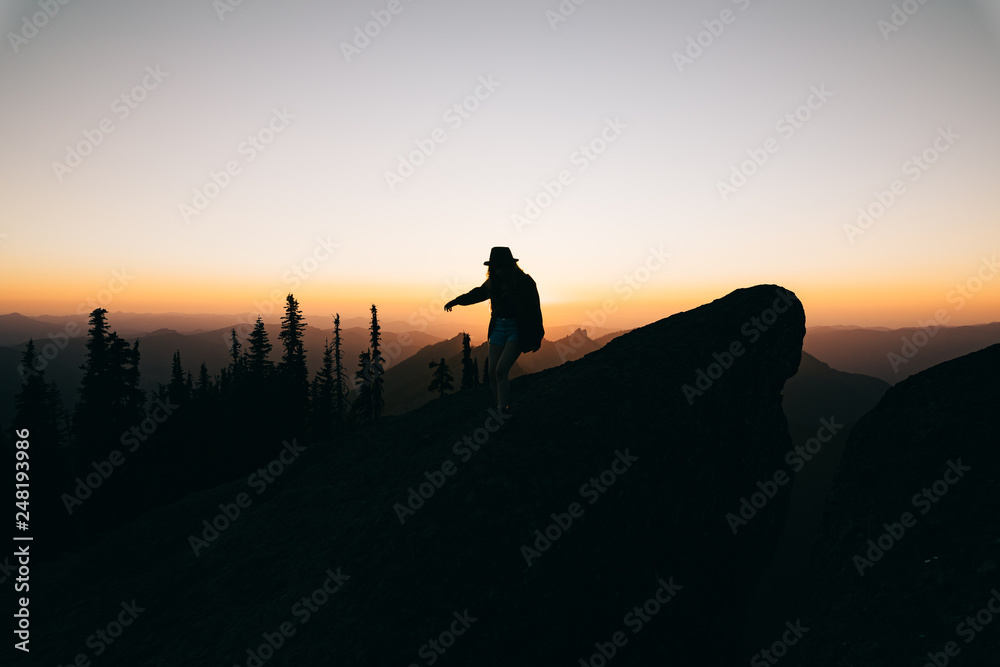 Silhouette of person walking on mountain during sunset Silhouette of person walking on mountain during sunset