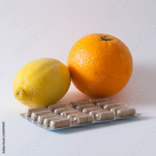 Citron, orange et gélules de compléments alimentaires photo