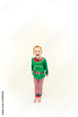 Beautiful little boy dressed like Christmas elf with big smile. Christmas concept. Studio portrait over green background