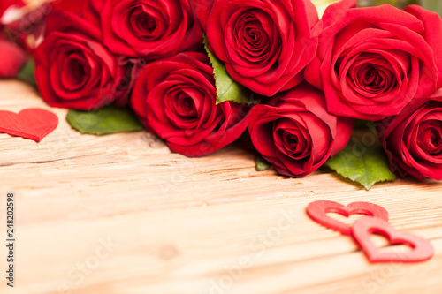 Rote Rosen Blumenstrauß mit Herzen auf Holz Tisch
