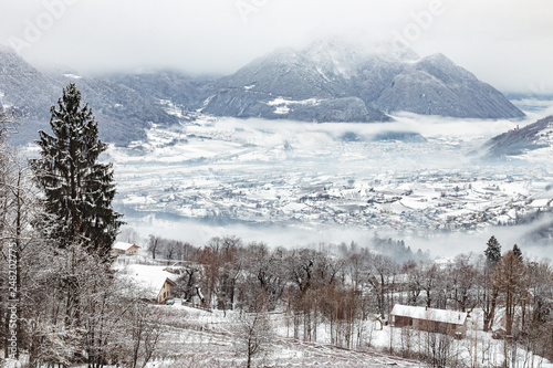 Cold foggy winter day in Valsugana, Sugana Valley, seen from Strigno, located at the Alps’ foothills in Trentino, Italy. Mystic landscape of the Dolomite mountains. photo