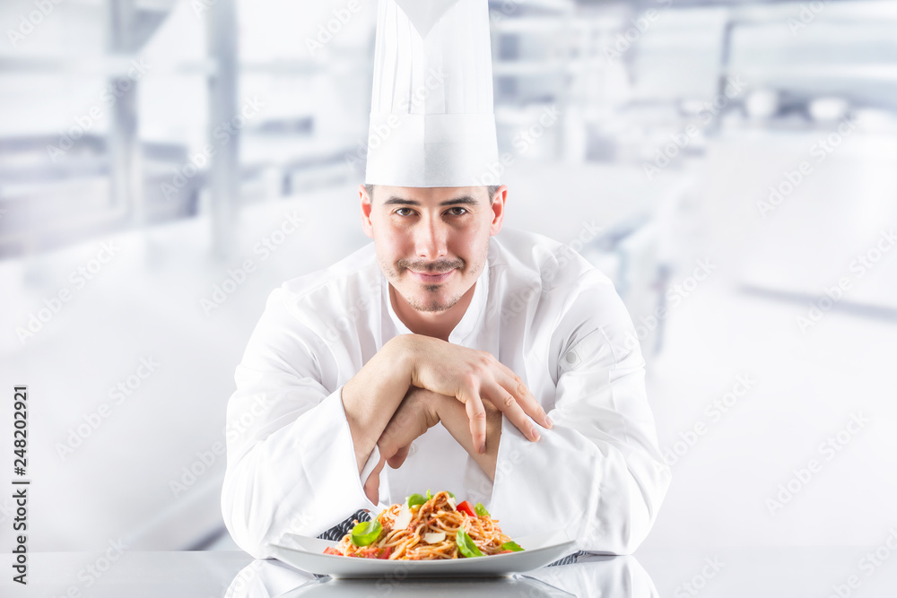 Chef in restaurant kitchen with plate from italian meal spaghetti bolognese Chef in restaurant kitchen with plate from italian meal spaghetti bolognese