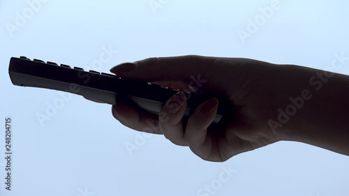 Woman hand operating a tv remote control isolated on white background