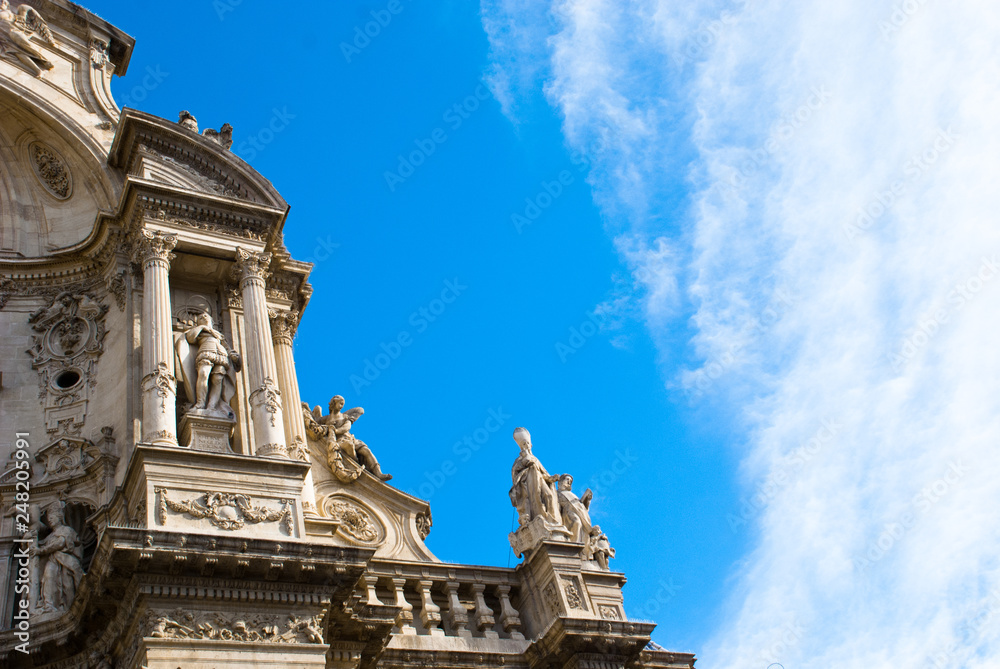 Part of facade of catholic cathedral  with columns and sky in Spain.Architecture of baroque and renaissance style.