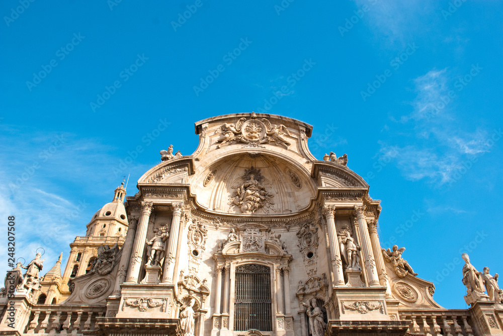 Part of facade of catholic cathedral  with columns and sky in Spain.Architecture of baroque and renaissance style.