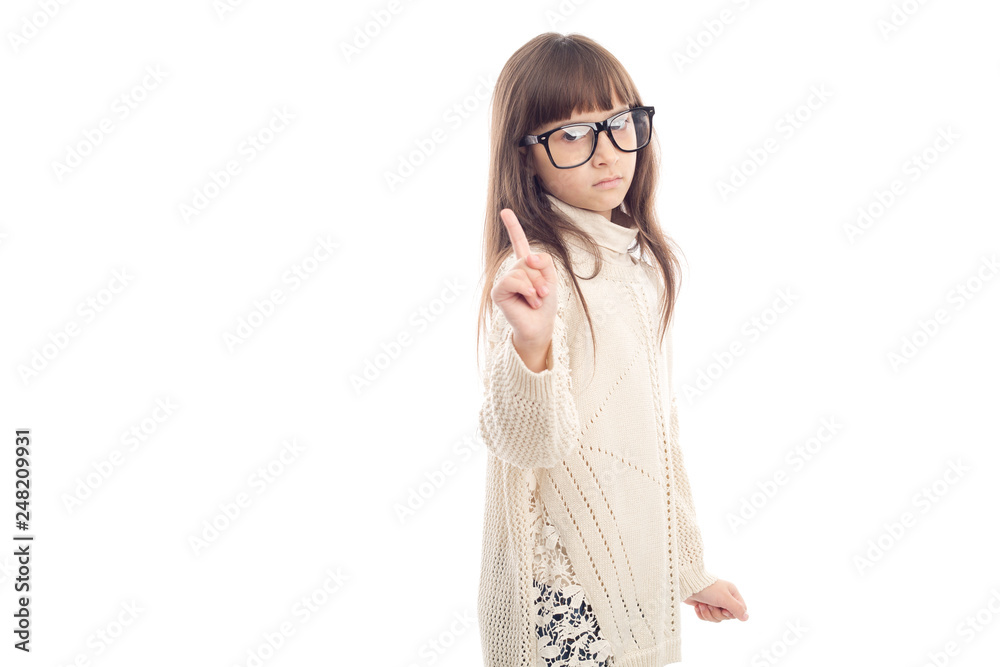 Warning. Serious little girl in glasses shows a finger up. Warning. Serious little girl in glasses shows a finger up.