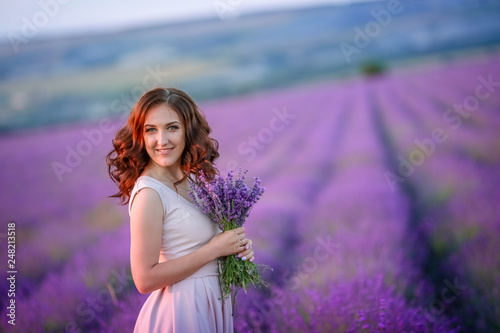 beautiful bride in luxurious wedding dress in purple lavender flowers. Fashion romantic stylish woman with violet bouquet. Alluring slim girl in sunset over lavenda waiting for groom - Provence France