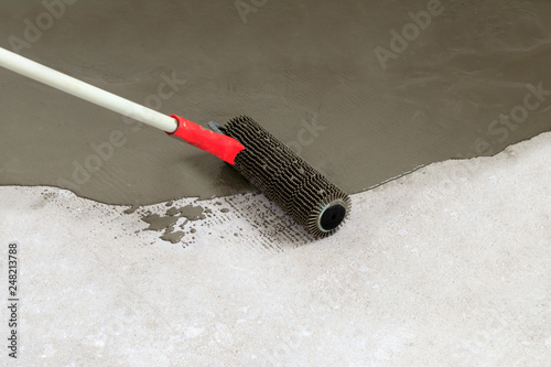 concrete floor. on the horizon. close-up. needle roller for removing air bubbles. have toning. then there will be painting