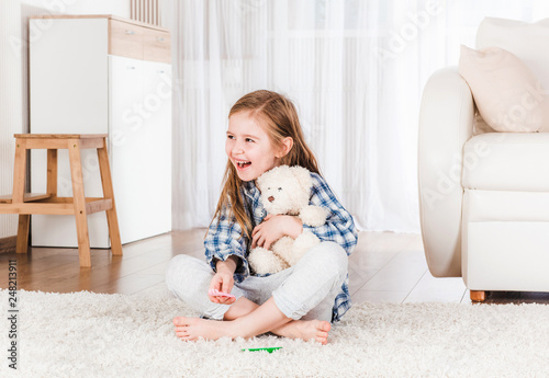 Girl playing with teddy bear