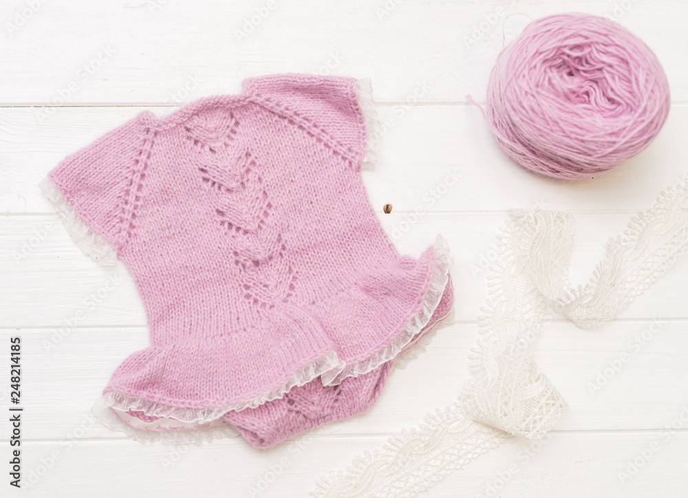 Fototapeta premium Composition of white-pink knitted suit and hat