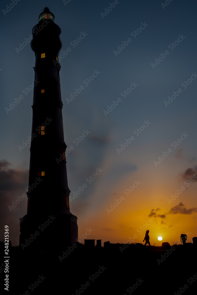 California Lighthouse at sunrise with people in silhouette on the island of Aruba
