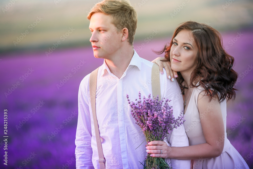 Portrait of young sensual loving couple in a lavender field at sunset. Provence, France