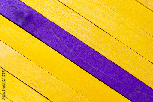 Yellow diagonal colored wooden background with purple stripe