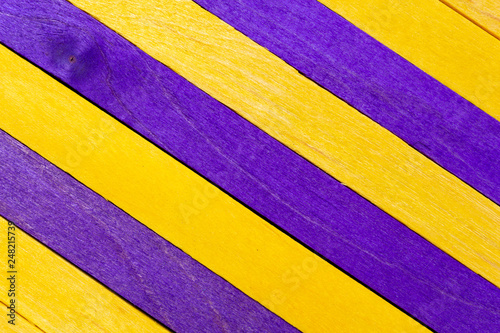 Yellow diagonal colored wooden background with purple stripes
