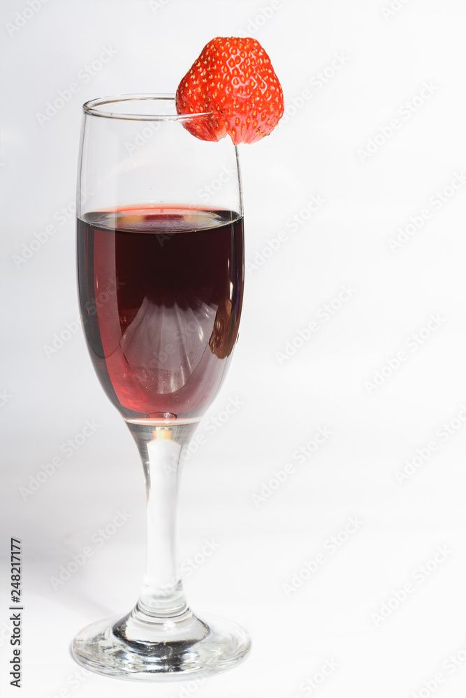 A glass of red wine with strawberries on a white background A glass of red wine with strawberries on a white background