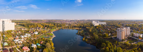 New district with high-rise buildings in the new Moscow on the background of low-rise private sector houses. © miklyxa