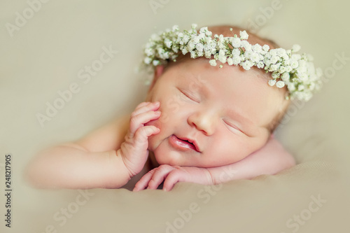 Newborn baby girl posing in tutu skirt and flower head band photo