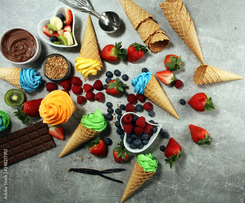 Vanilla frozen yogurt or colorful soft ice cream in waffle cone.