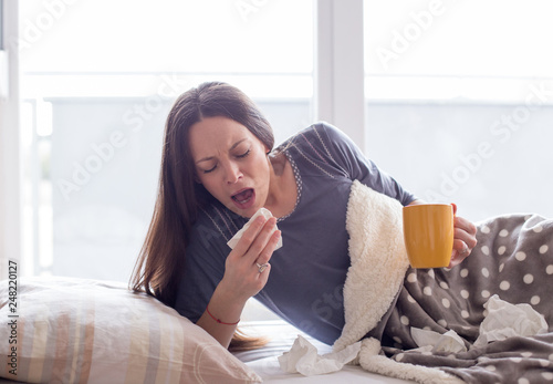 Girl sneezing in bed