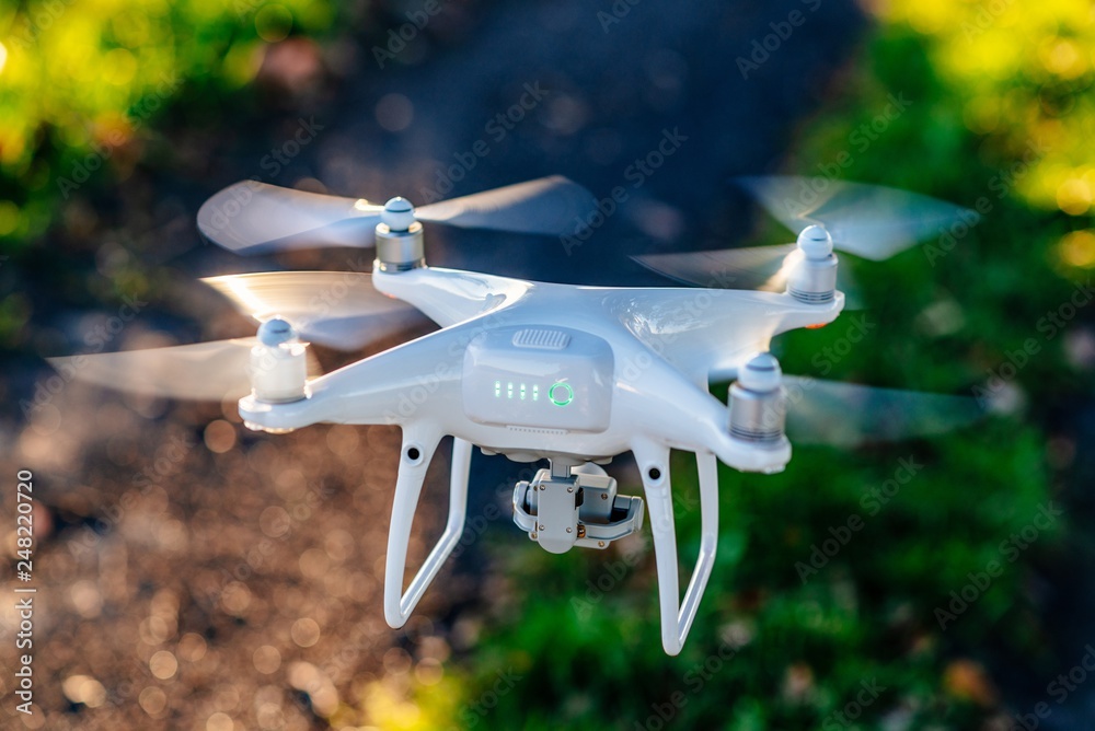 White drone quadrocopter in flight.