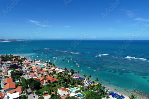 Aerial view of Porto de Galinhas beaches  Pernambuco  Brazil  unique experience of swimming with fishs in natural pools.  Beautiful landscape. Candles  sailboats  rafts  boats in the harbor 