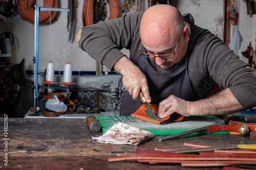 craftsman working the leather in his small saddlery workshop