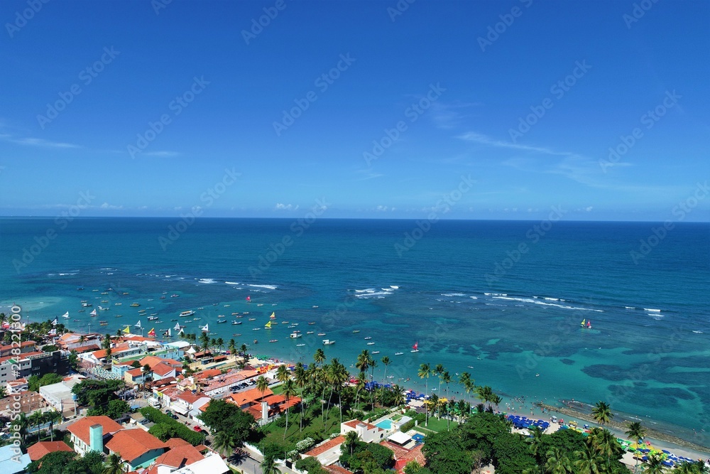 Aerial view of Porto de Galinhas beaches, Pernambuco, Brazil: unique experience of swimming with fishs in natural pools.  Beautiful landscape. Candles, sailboats, rafts, boats in the harbor!