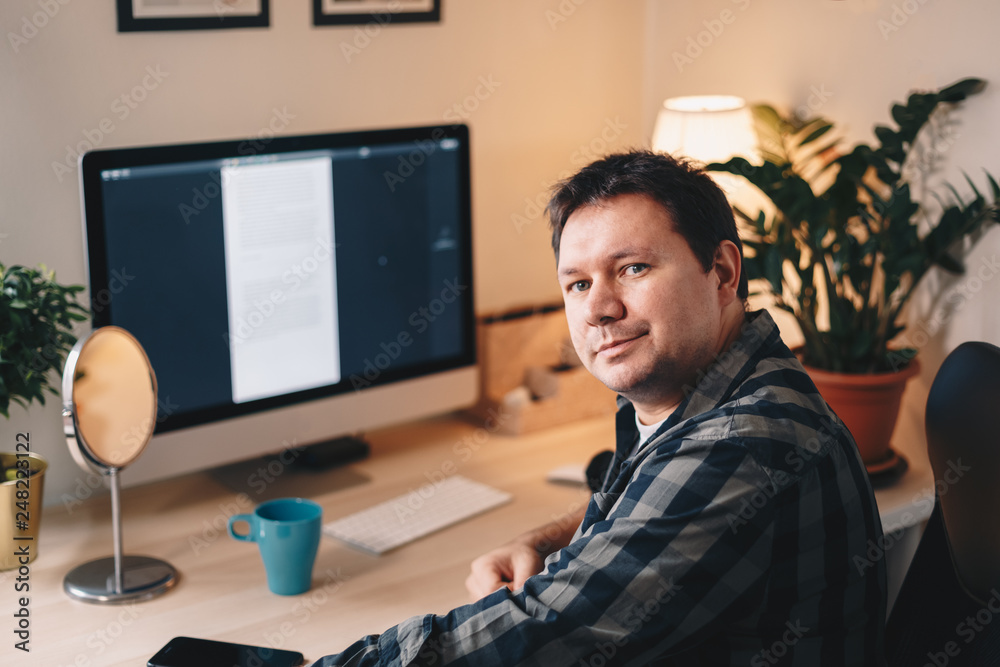 Portrait of a handsome young male writer posing in his home office, looking at the camera. Portrait of a handsome young male writer posing in his home office, looking at the camera.