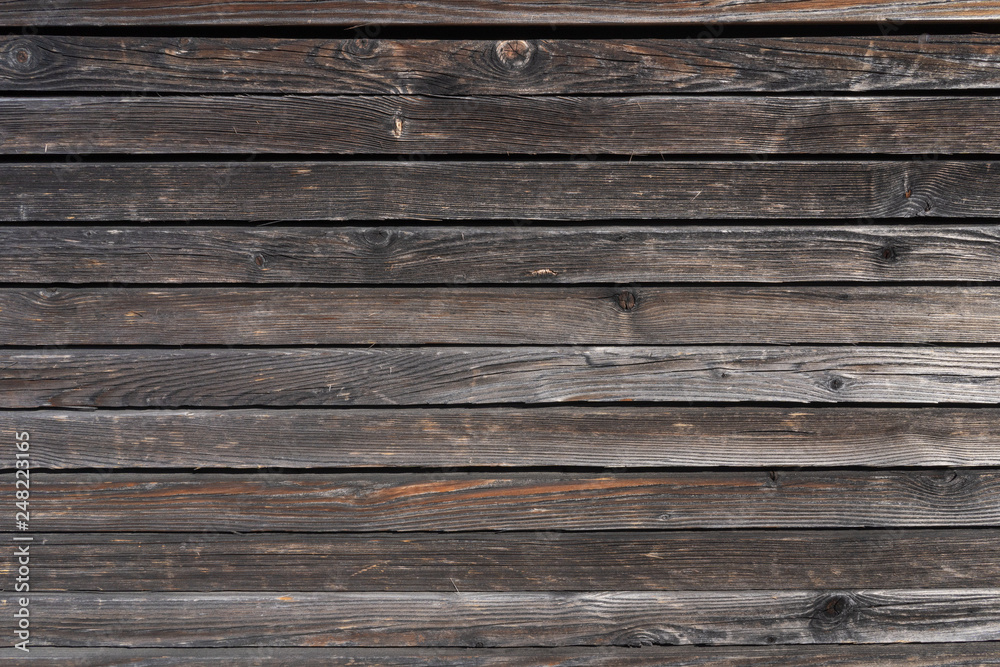 Surface of a heavily weathered planking of a facade made of wooden slats Surface of a heavily weathered planking of a facade made of wooden slats