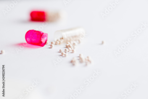 open two-colored capsule of medication with loose contents