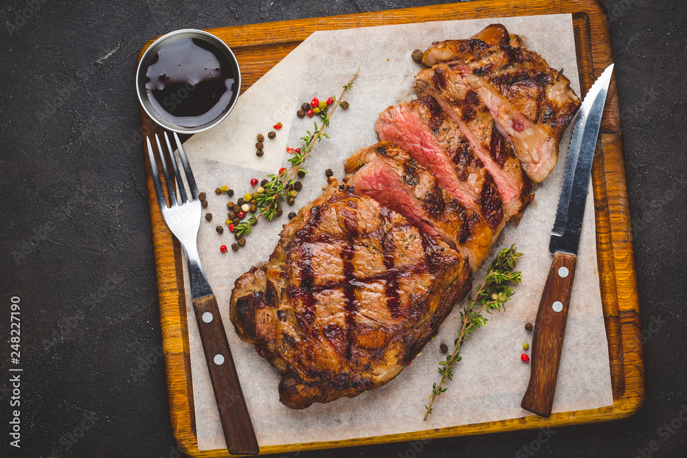 Succulent grilled large striploin steak garnished with herbs and salt