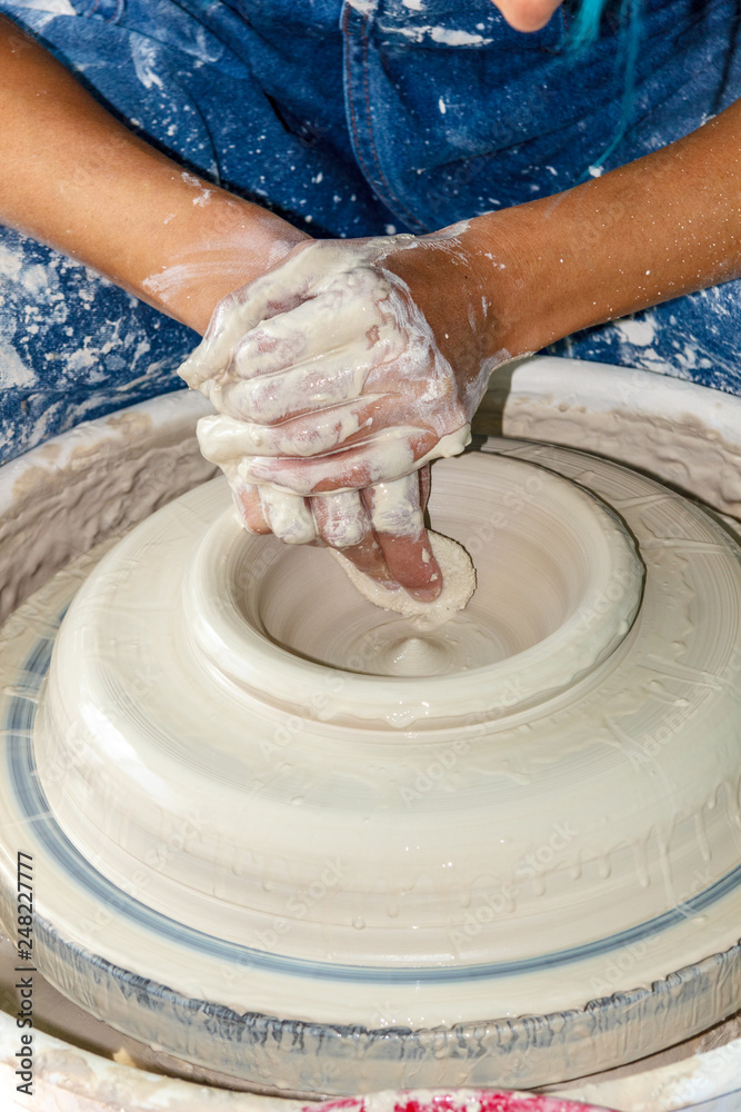 Potter hrowing a pot on a wheel Potter hrowing a pot on a wheel