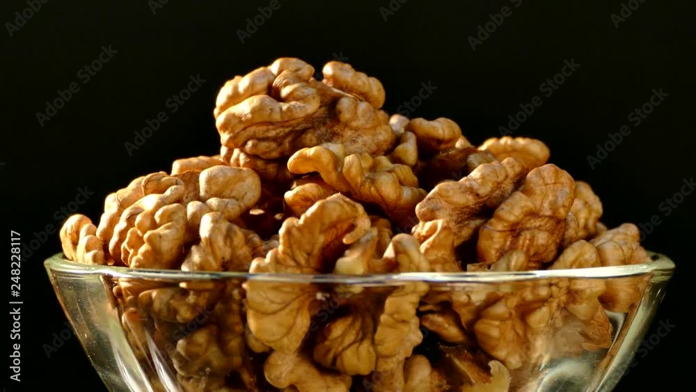 Walnut closeup. Nuts without shell on a black background. Kernels scattered on the table.