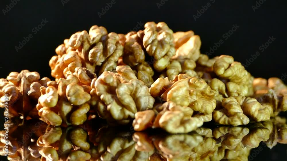 Walnut closeup. Nuts without shell on a black background. Kernels scattered on the table. Walnut closeup. Nuts without shell on a black background. Kernels scattered on the table.