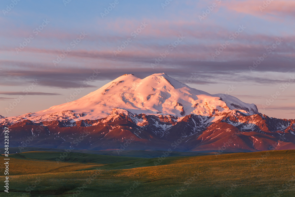 Mount Elbrus in summer morning at sunrise. Mountain landscape in North Caucasus, Karachay-Cherkessia, Russia